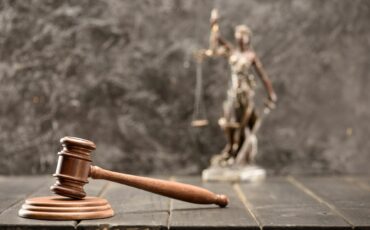Close-up view of brown mallet of judge on wooden table, law concept
