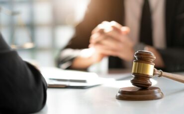 Judge gavel with Justice lawyers having team meeting at law firm in background. Concepts of law.